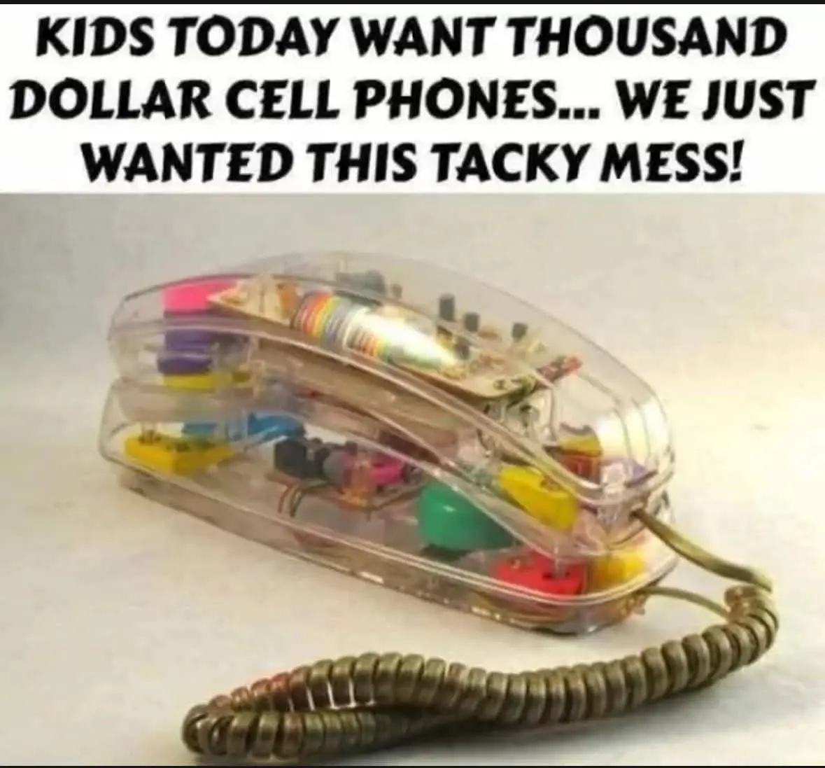 A clear plastic rotary telephone with colorful internal components and a coiled cord is shown against a plain background…