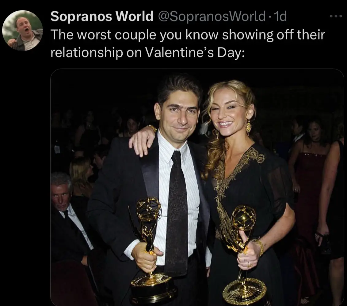 A man and woman in formal attire pose together, each holding a golden Emmy Award statue. The woman has her arm around the…