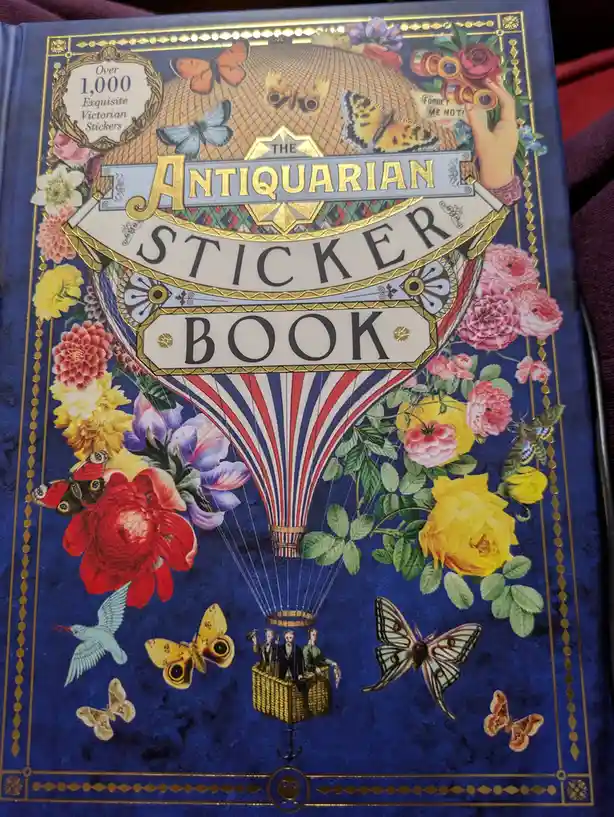 The cover of 'The Antiquarian Sticker Book' features a Victorian-style illustration with a hot air balloon carrying three…