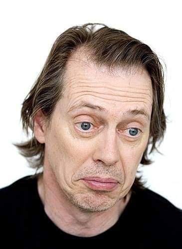 A man with medium-length brown hair and blue eyes stares directly at the camera with a wide-eyed, slightly confused, and…