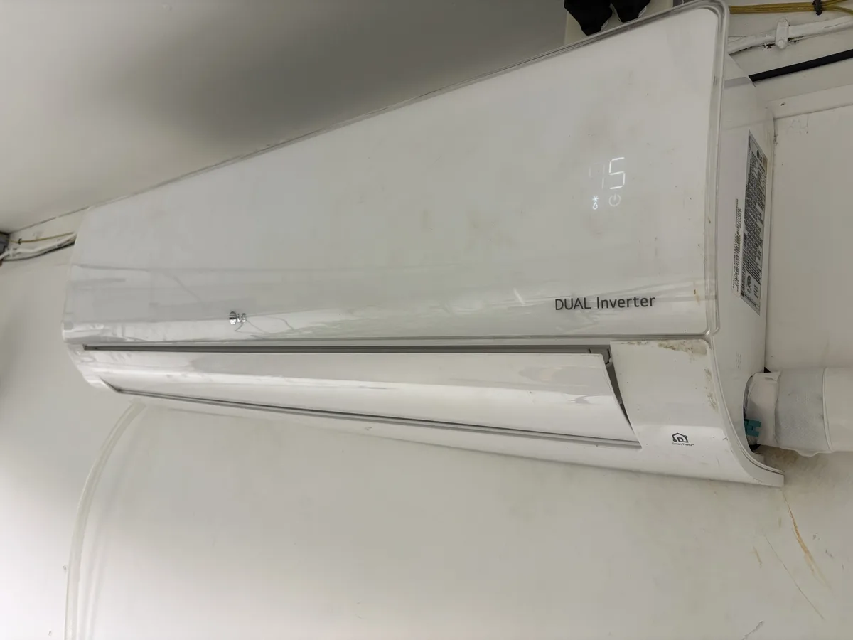 A white LG wall-mounted air conditioner unit is shown, displaying the number 75 on its digital screen, with visible dirt and…