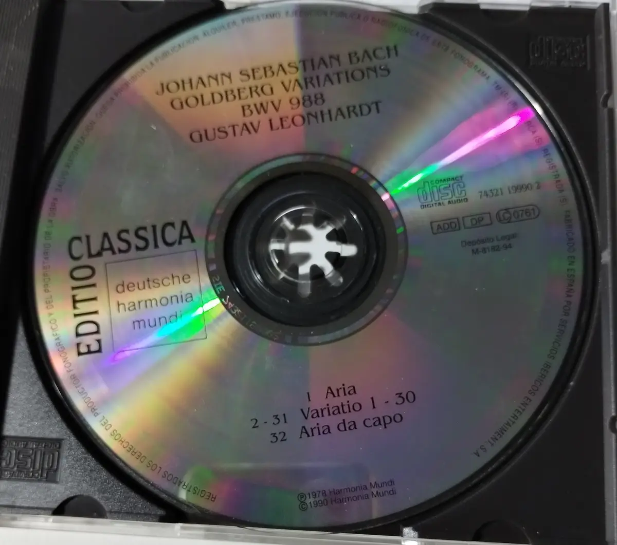 A close-up of a classical music CD by Gustav Leonhardt performing Bach's Goldberg Variations, showing track listings and the…