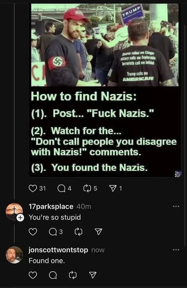 An image of a man wearing a Nazi armband and a red cap stands beside another man wearing a shirt with political slogans…