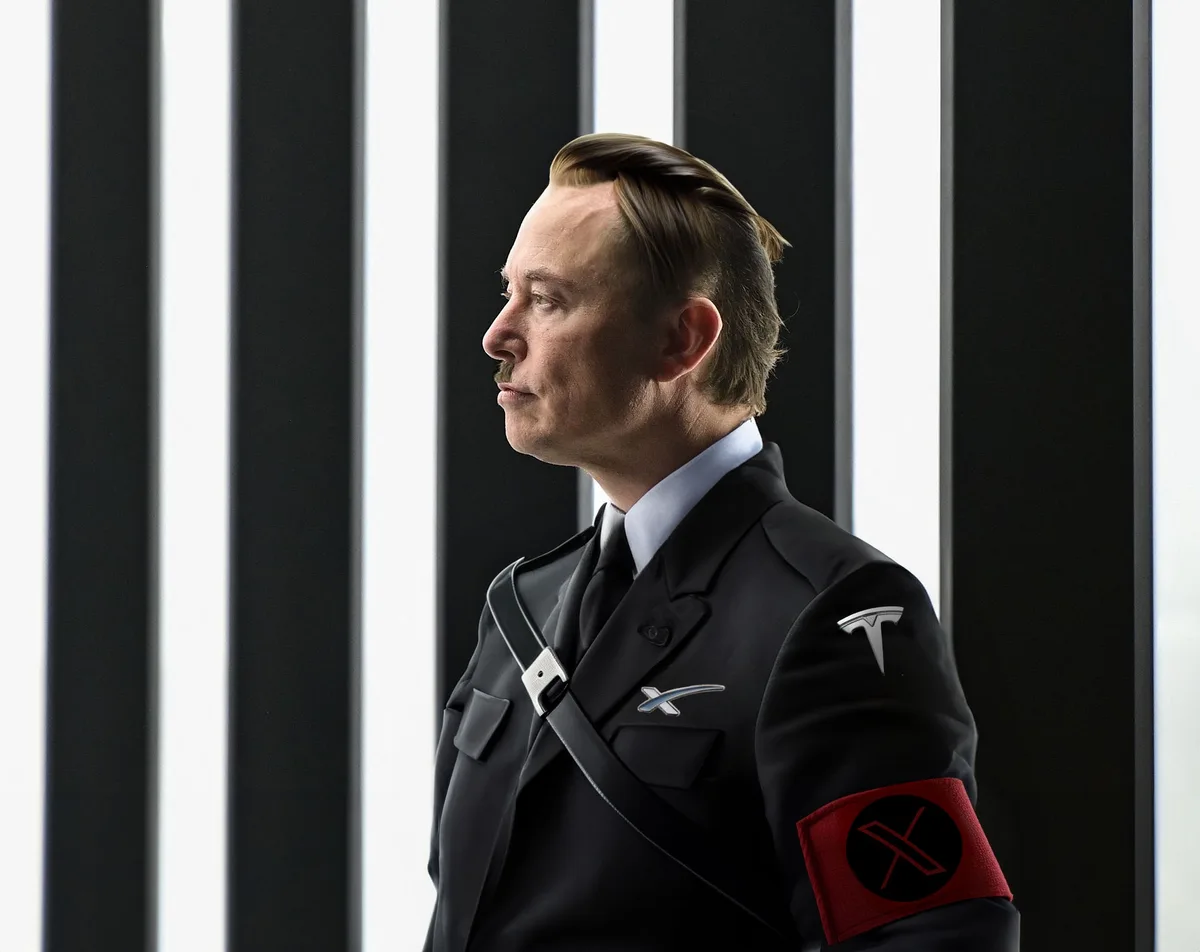 A man in a dark uniform with a red armband featuring a black 'X' stands in front of black and white vertical bars. The…