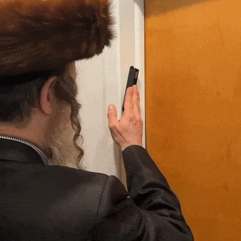 A man in traditional Jewish attire, including a fur hat and long beard, is shown in a six-panel sequence. He first taps a…