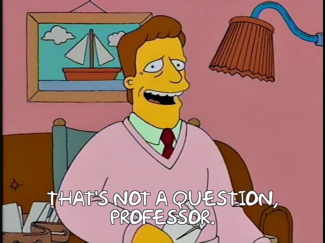 A still from The Simpsons shows a man in a pink sweater and red tie sitting in a chair, smiling broadly with his mouth open…