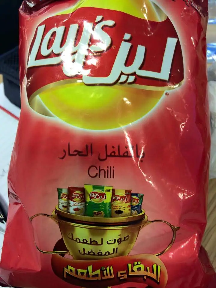 A red bag of Lay's potato chips with Arabic text overlaid. The text reads 'Lay's' in English and Arabic, 'بالفلفل الحار'…