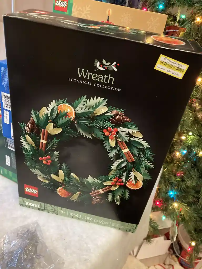 A black LEGO box for the 'Wreath Botanical Collection' set (10340) is shown, featuring an image of a Christmas wreath made…