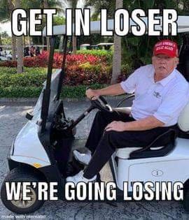 A man in a white polo shirt and red cap sits in a white golf cart, gripping the steering wheel with a stern expression…