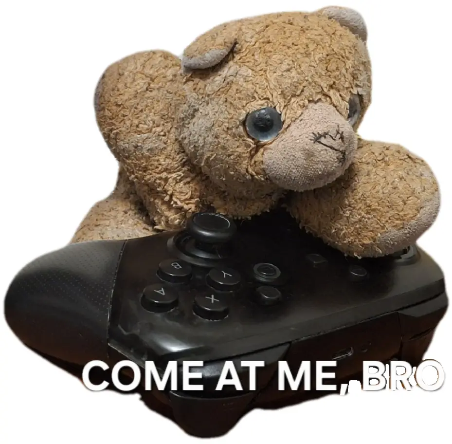 A worn, shaggy brown teddy bear with stitched eyes and a stitched mouth is leaning over a black video game controller…
