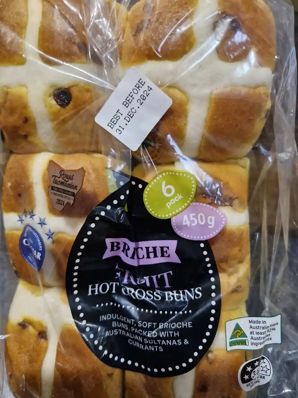 A close-up of a plastic-wrapped package of 'Briche Fruit Hot Cross Buns' with a white sticker overlaid that reads 'BEST…