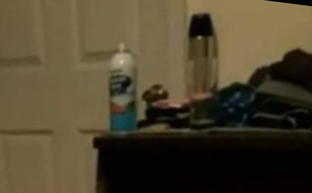 A blurry photo shows a cluttered surface with a can of air freshener, a thermos, and miscellaneous items. Overlaid text…