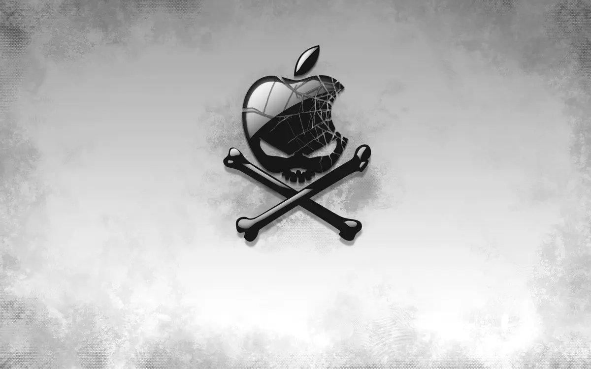 A grayscale image features a cracked Apple logo with a skull face superimposed over it, positioned above two crossed bones…