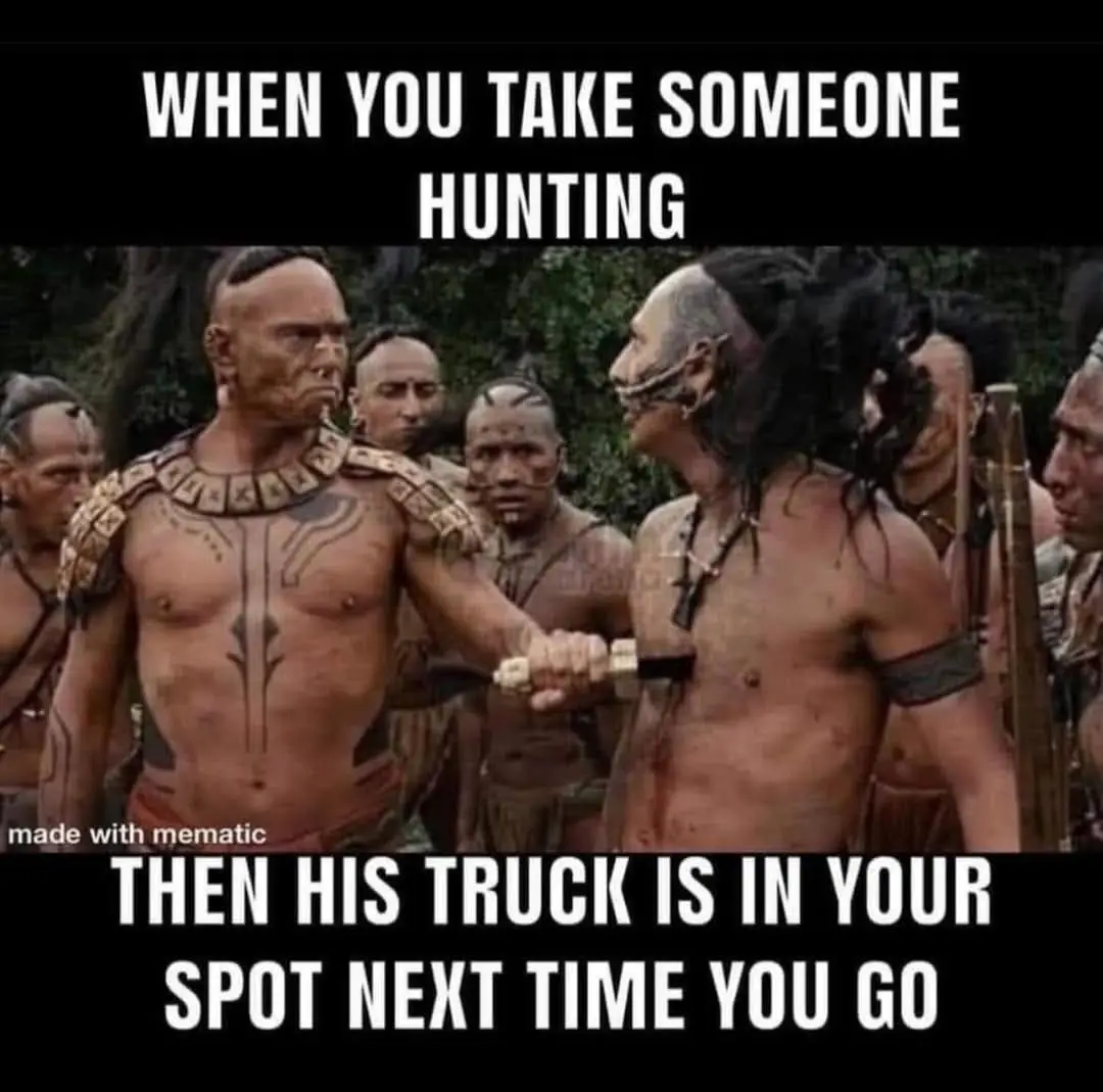 A scene from a movie showing two men in tribal attire facing each other, one holding a weapon, with a group of onlookers…