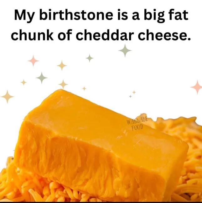 A large, solid block of orange cheddar cheese sits atop a bed of shredded cheddar cheese, with sparkly star graphics…