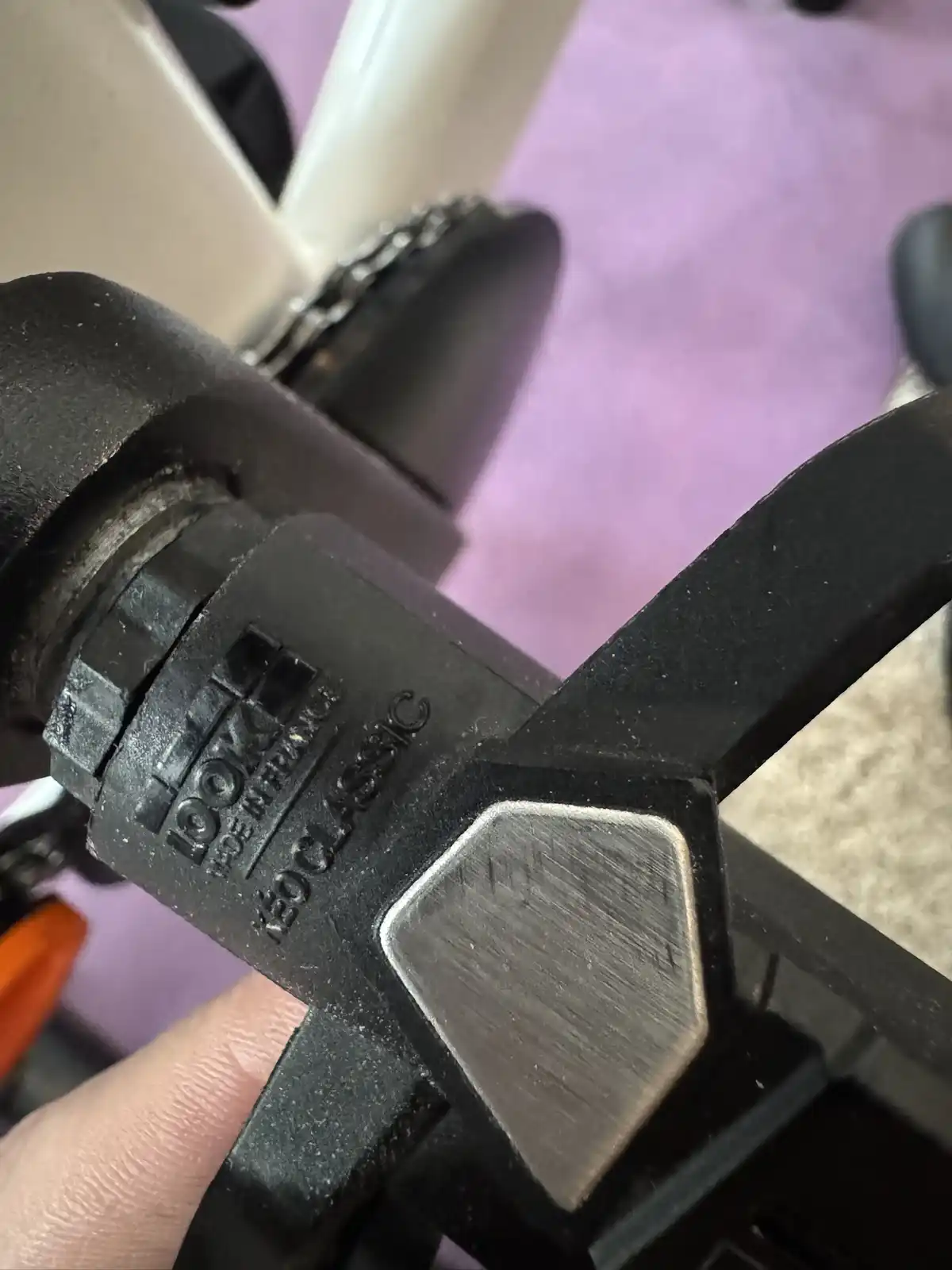 A close-up photo shows a hand holding a black bicycle component, likely a headset or stem, with visible embossed text…