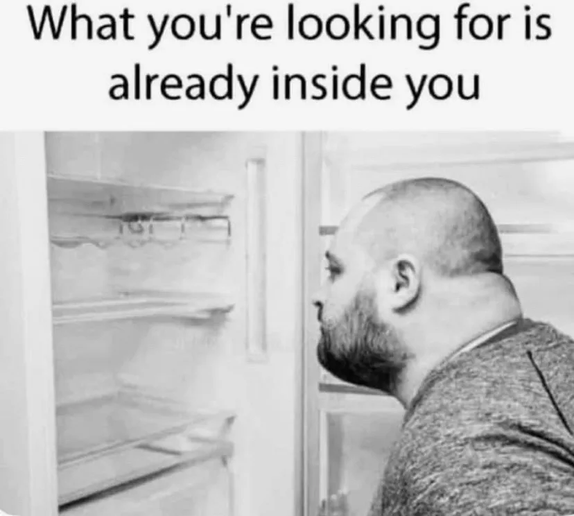 A black-and-white photo shows a bald man with a beard looking into an empty refrigerator. The text overlaid at the top reads…