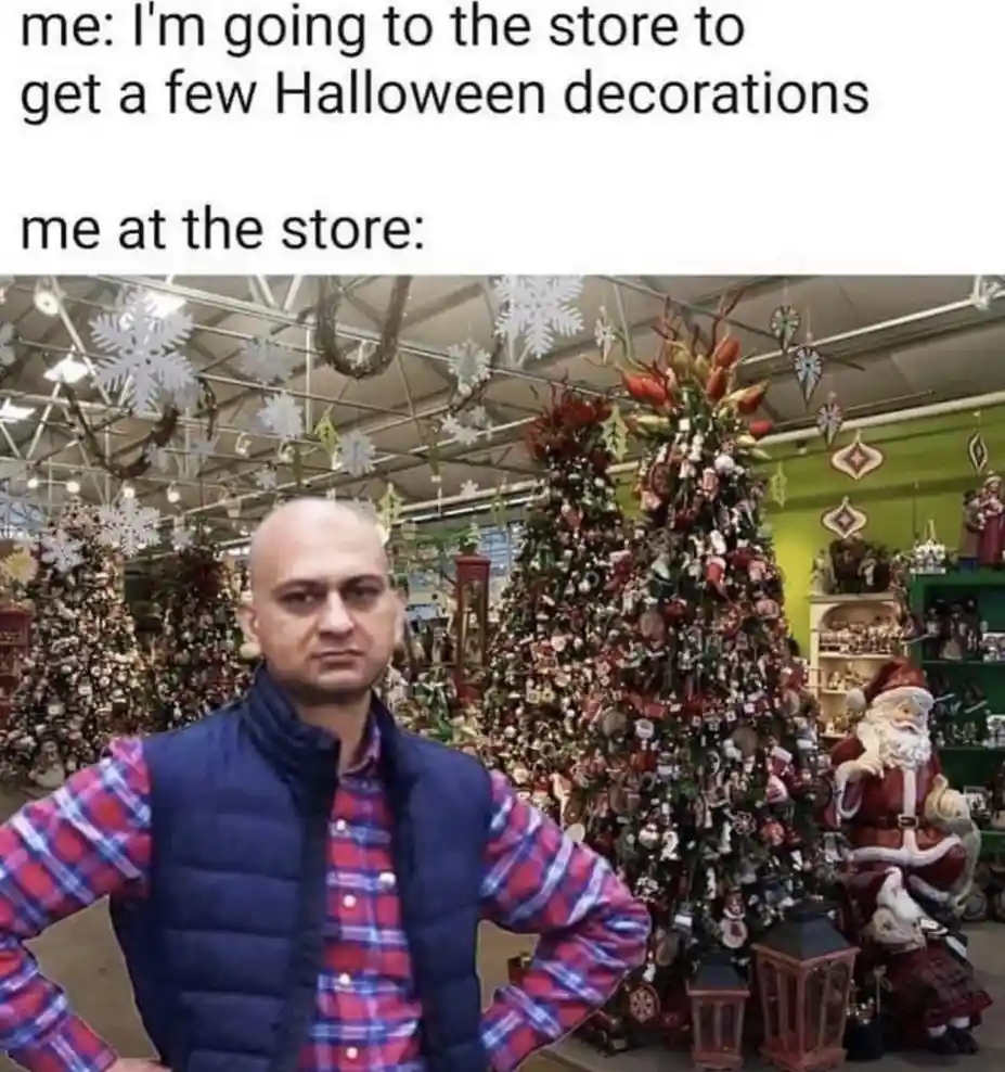 A man with a stern expression stands with hands on hips in a store filled with Christmas decorations, including large…