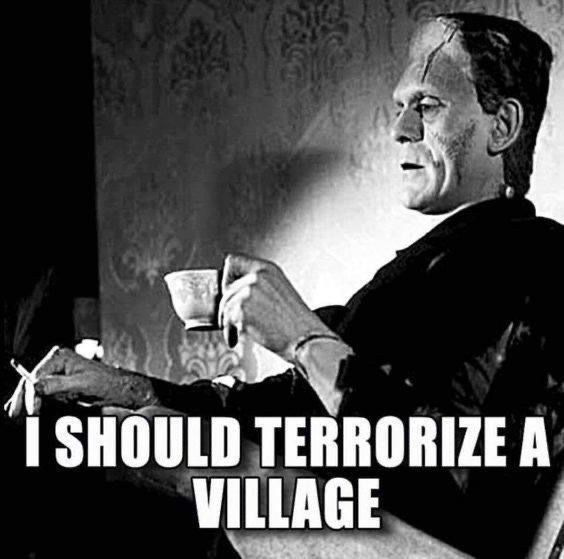 A black-and-white photo of a man resembling Frankenstein's monster calmly holding a teacup and cigarette while seated. The…