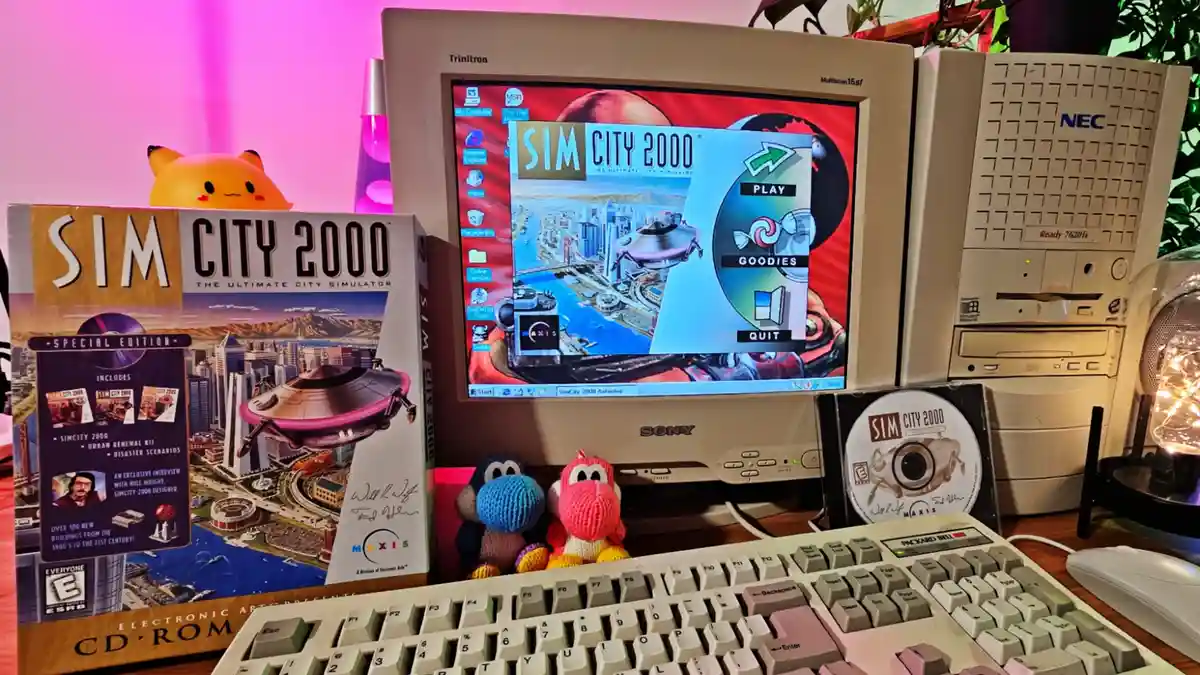 A vintage beige NEC computer setup displays the 'Sim City 2000' game main menu on its CRT monitor, flanked by the game's…