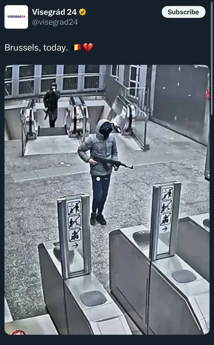 A grainy security camera image shows two masked individuals in a public transit station, one in the foreground holding an…