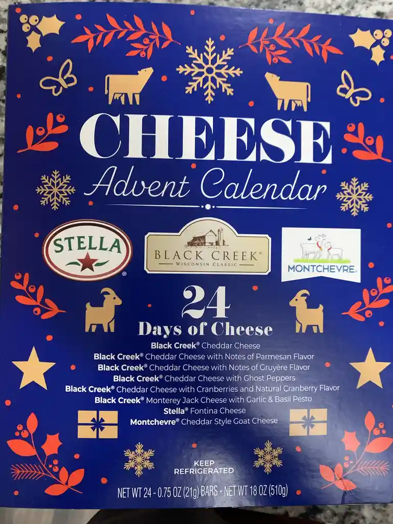 A blue cheese advent calendar box decorated with gold and red holiday motifs like snowflakes, holly, and goats. It features…
