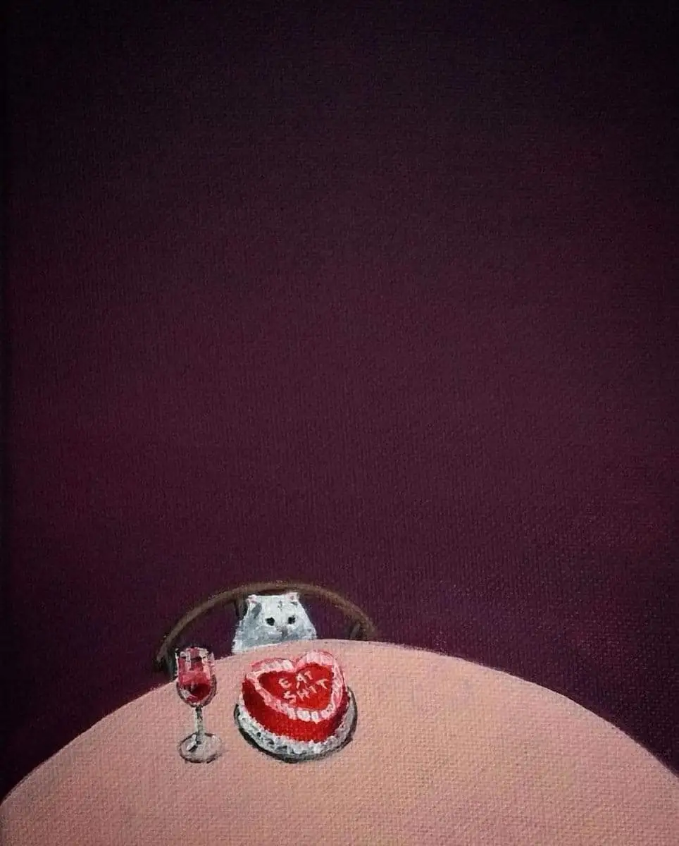 A small white cat sits at a table with a glass of red wine and a heart-shaped cake that reads 'CAT SHIT'. The scene is set…