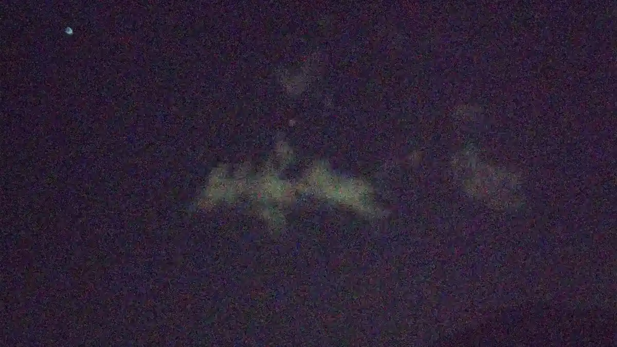 A heavily pixelated and grainy image shows a blurry, indistinct shape resembling a person or object against a dark, noisy…