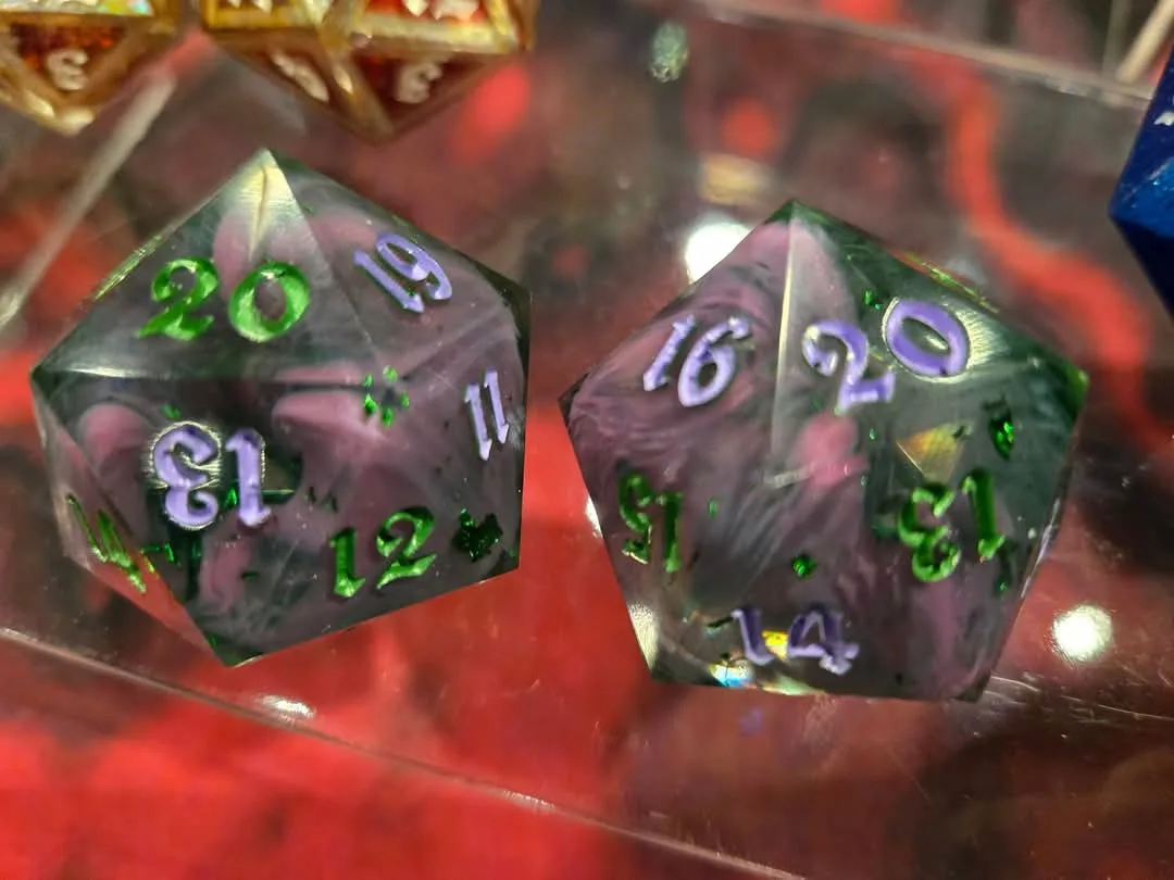 Two translucent, marbled 20-sided dice rest on a reflective surface, showing numbers like 20, 19, 16, and 13. The overlaid…