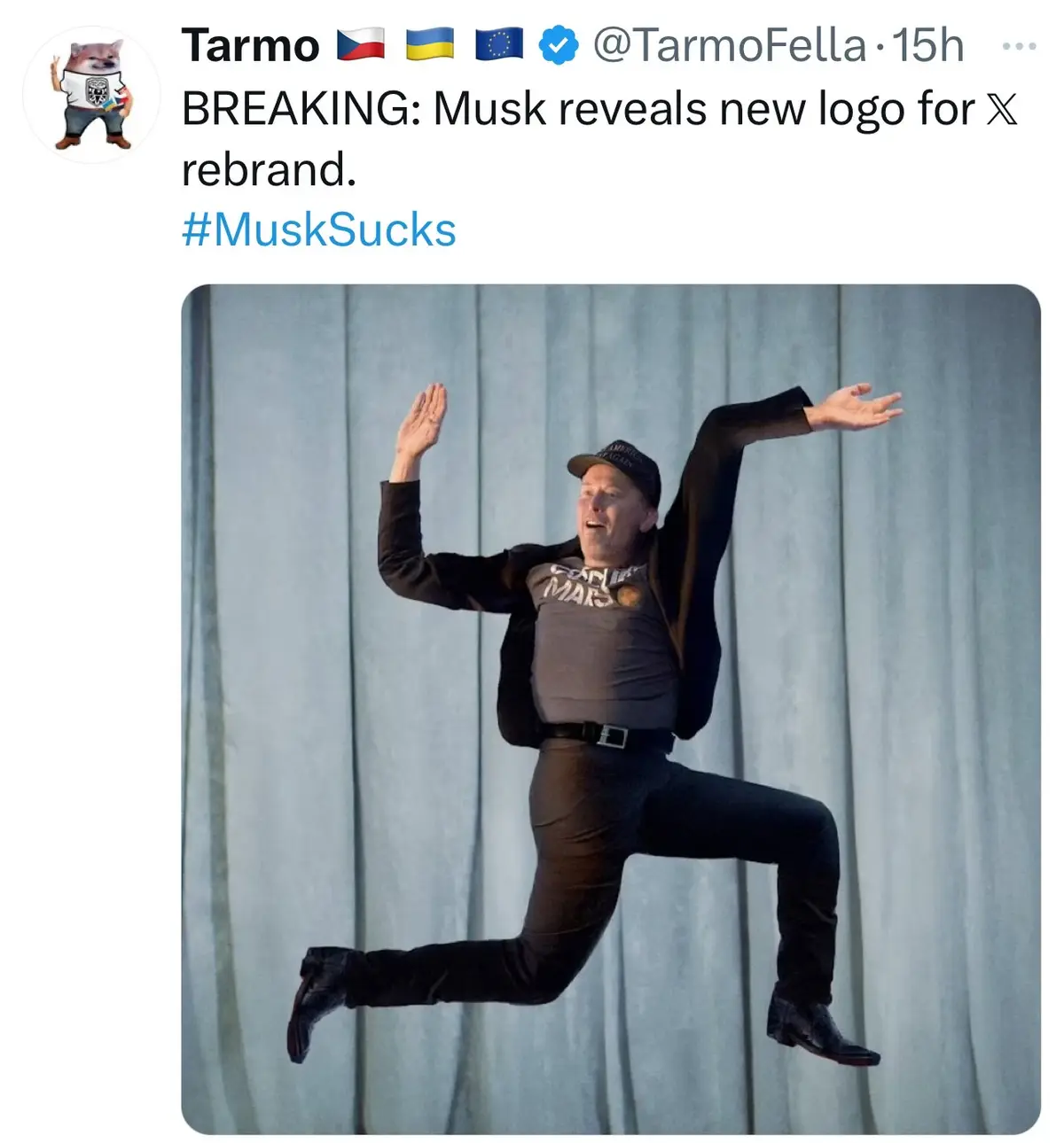 A man in a black jacket, grey t-shirt with 'COOL MARS' text, and a cap is captured mid-air in a dynamic jumping pose against…