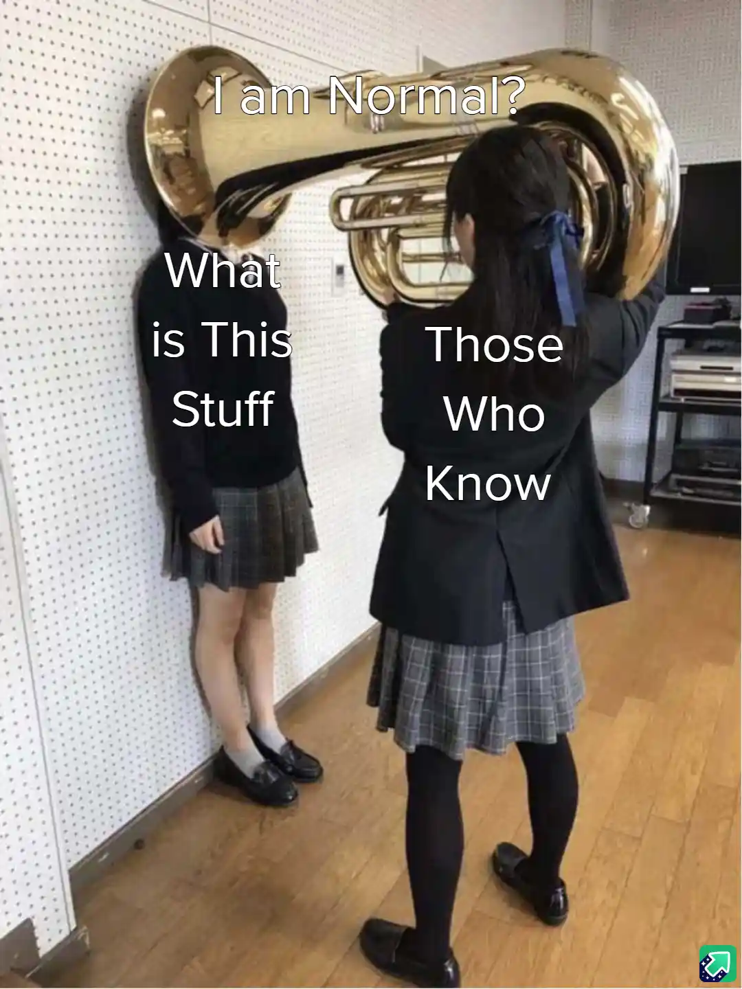Two girls in school uniforms stand in a room; one holds a large brass tuba, obscuring her face, while the other leans…