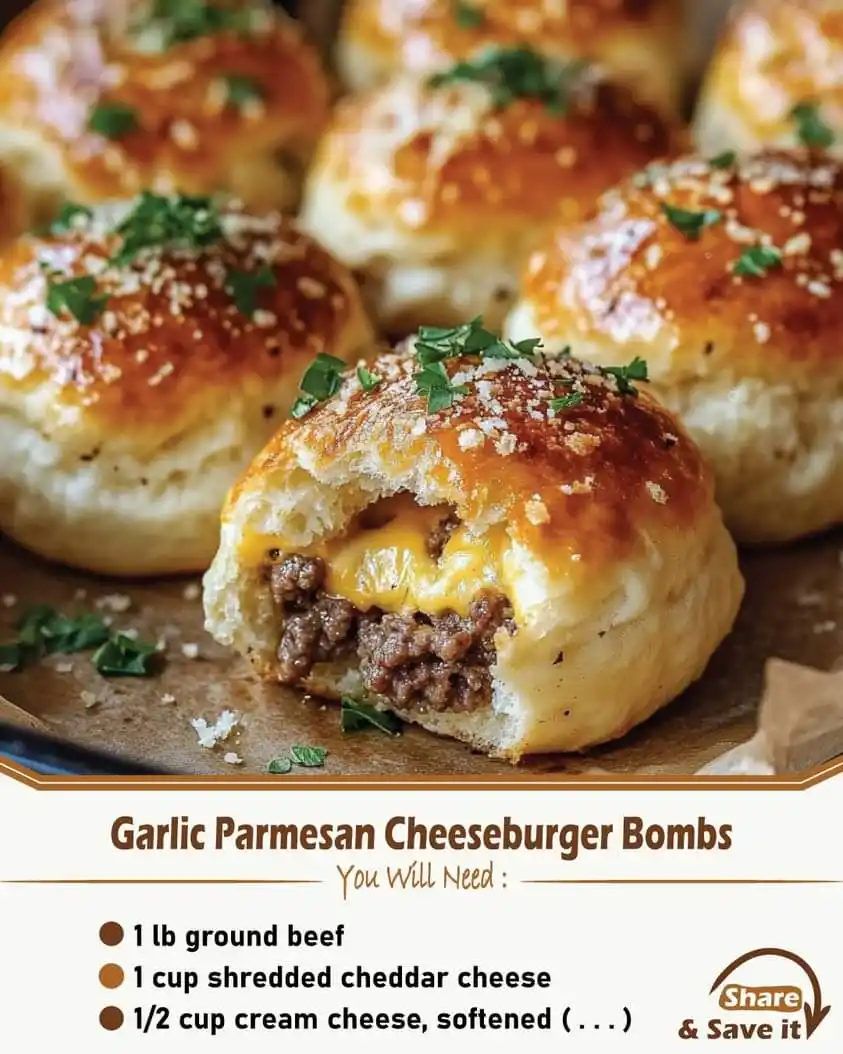 A close-up photo of golden-brown, baked cheeseburger bombs with a bite taken out, revealing melted cheese and ground beef…