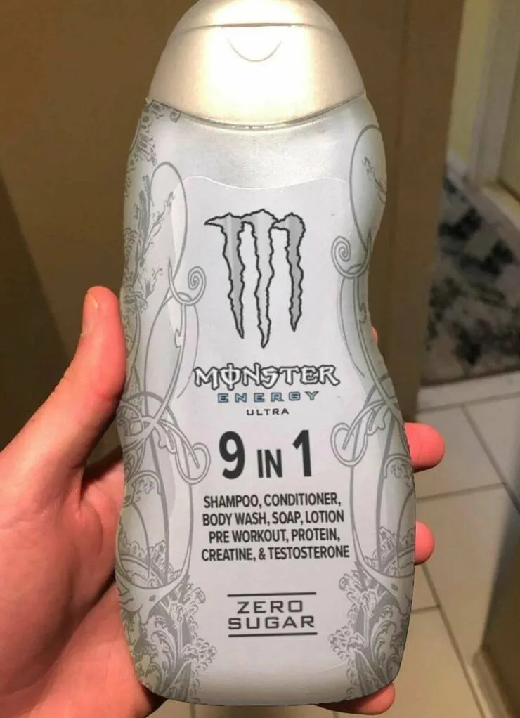A hand holds a silver bottle of Monster Energy Ultra labeled as '9 in 1' containing shampoo, conditioner, body wash, soap…