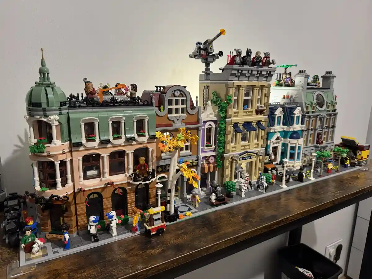 A detailed Lego city street scene featuring multiple buildings with varied architectural styles, including a police station…