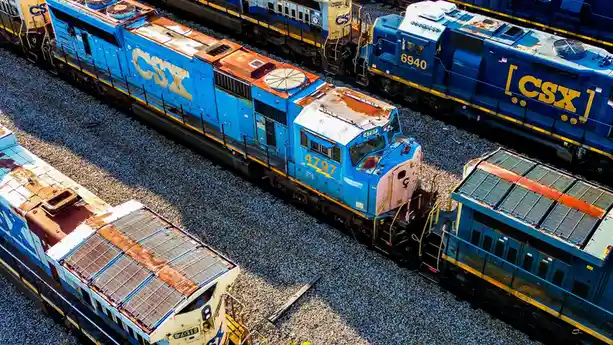 An aerial view of several rusty CSX freight locomotives parked on gravel railroad tracks, with the number 4797 visible on…
