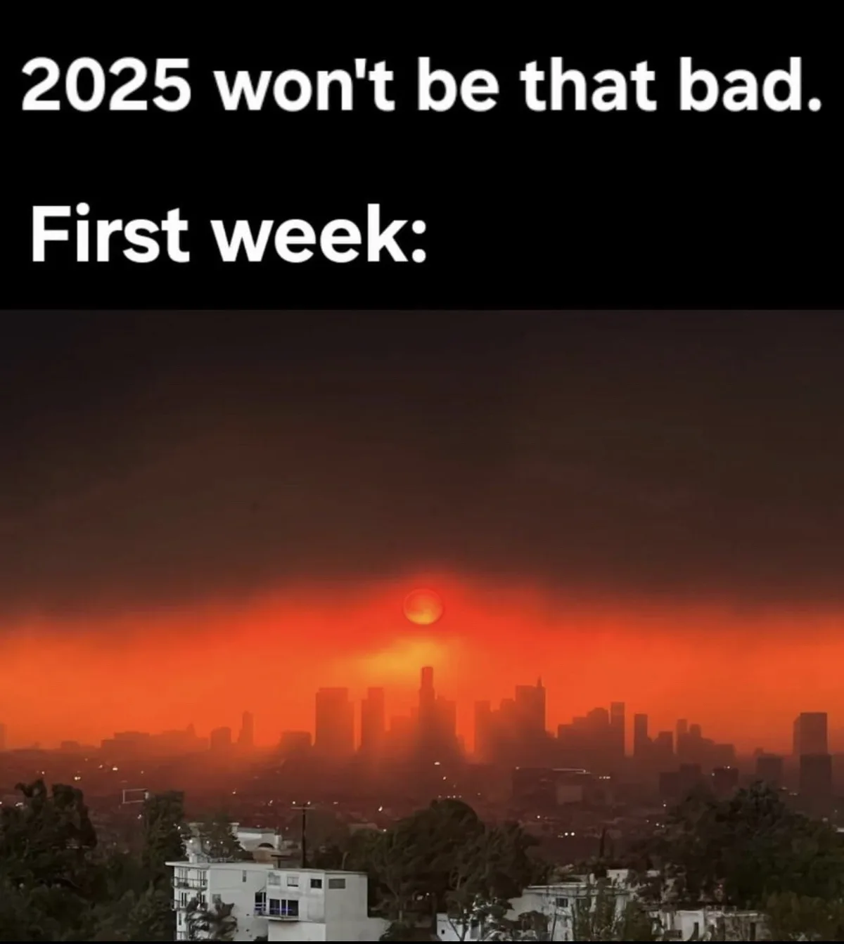 The image shows a city skyline under a dark, ominous sky with a glowing orange-red sun low on the horizon, suggesting a…