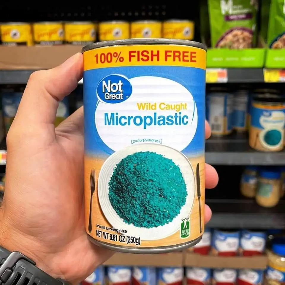 A hand holds a can labeled 'Not Great' with 'Wild Caught Microplastic' and '100% FISH FREE' on a yellow banner. The can…