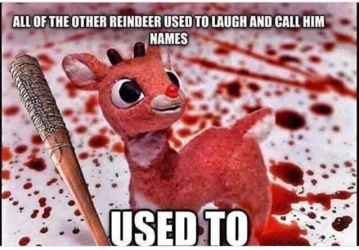 A small, red, plush reindeer toy with large eyes and a red nose stands amidst a background splattered with red, resembling…