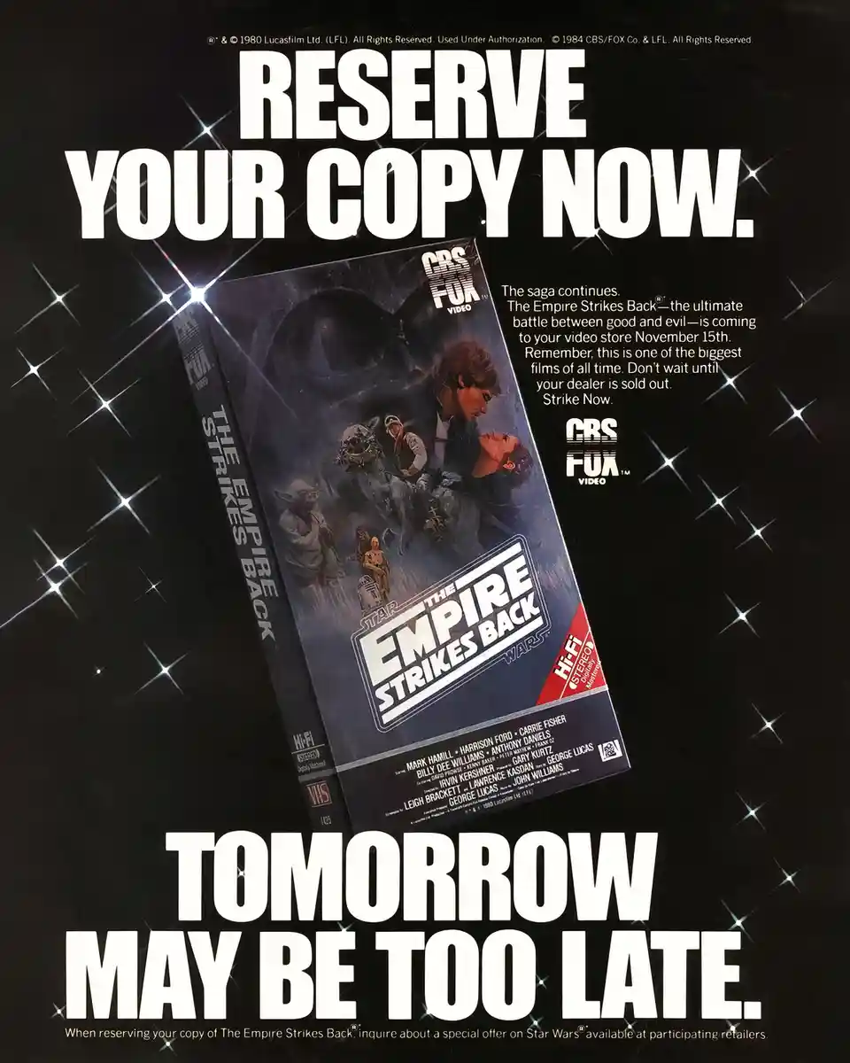 A vintage 1984 CBS/Fox Video advertisement for the VHS release of 'Star Wars: The Empire Strikes Back' features a tilted VHS…