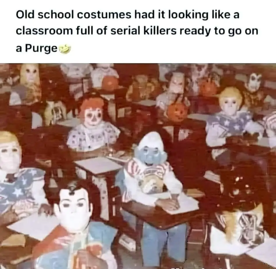 A vintage, grainy photo shows children in a classroom, all wearing elaborate and unsettling Halloween costumes including…