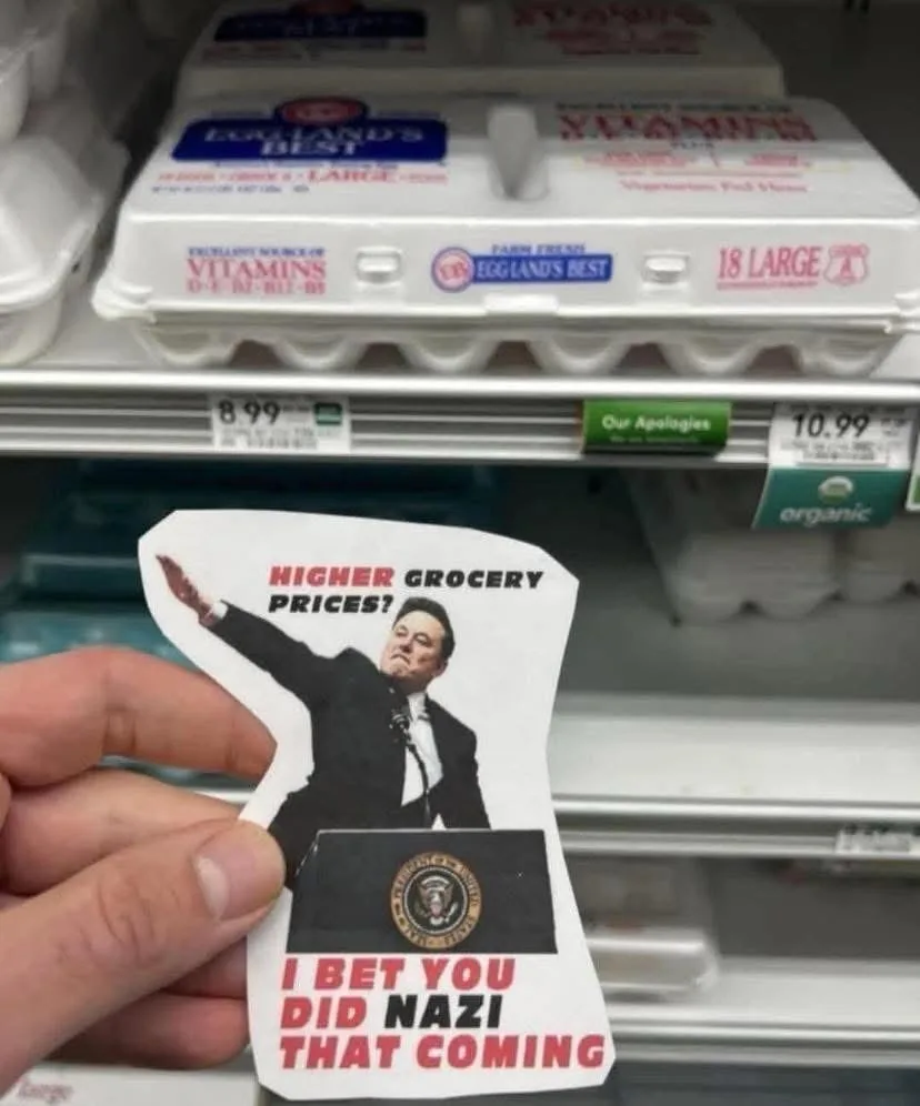 A hand holds a cutout image of a man in a suit at a podium with the presidential seal, set against a background of grocery…