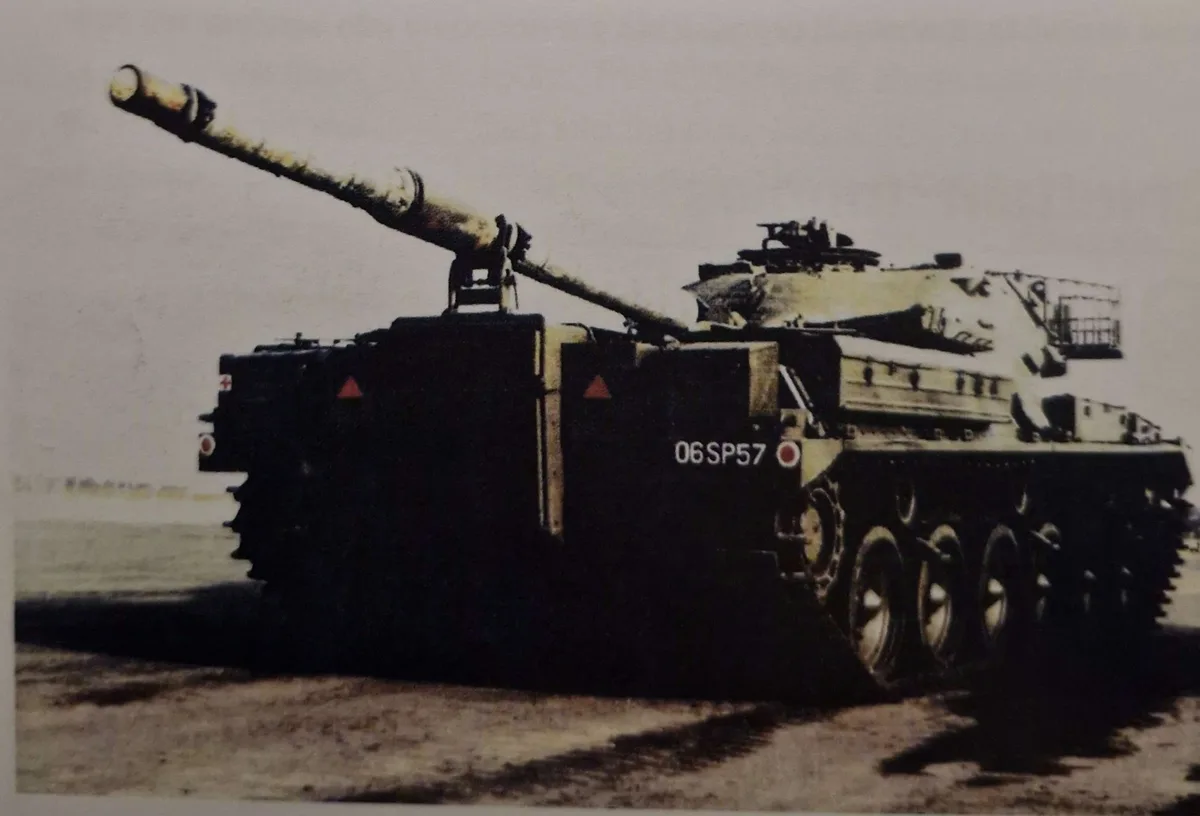 A military tank with a long cannon barrel is shown in profile, its hull marked with the number '06SP57'. The overlaid text…