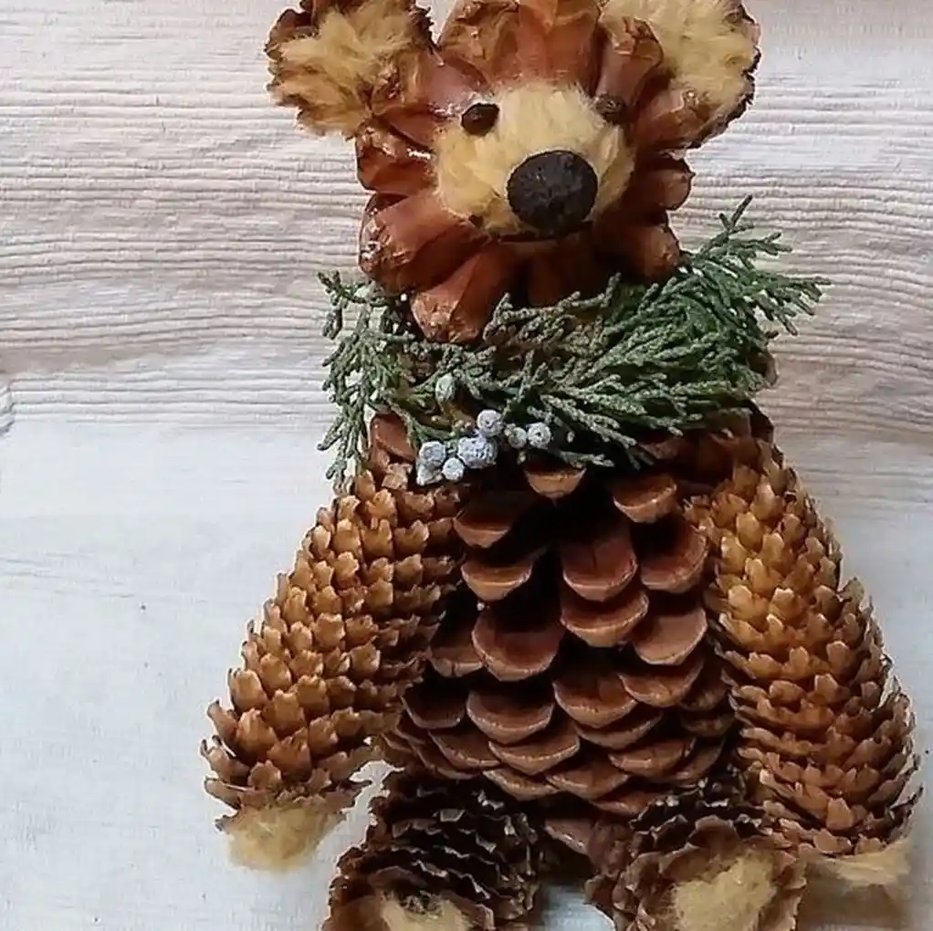 A handmade bear crafted entirely from pinecones, featuring a pinecone head with fuzzy ears, a pinecone body, and pinecone…