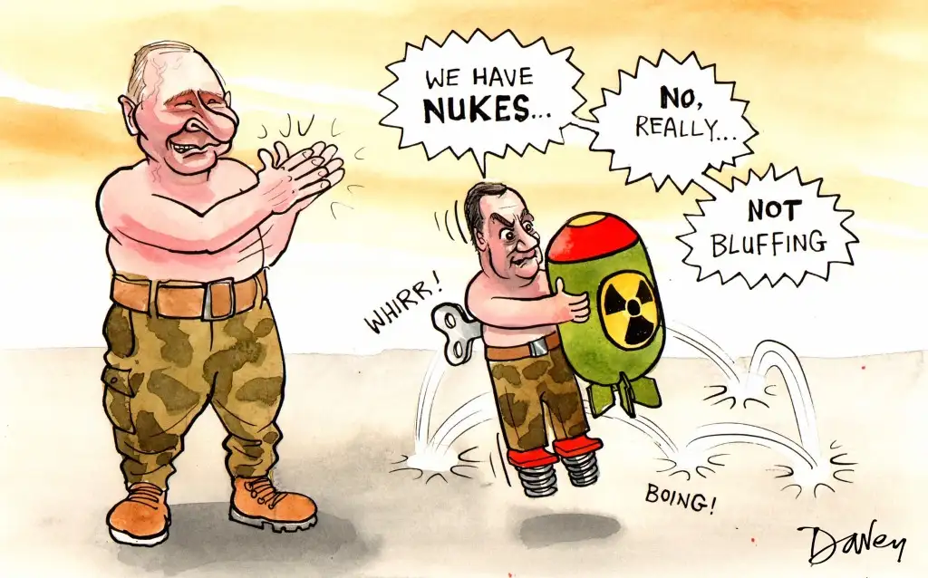 A cartoon depicts two men in military-style pants. The larger man on the left claps and says 'WE HAVE NUKES...'. The smaller…