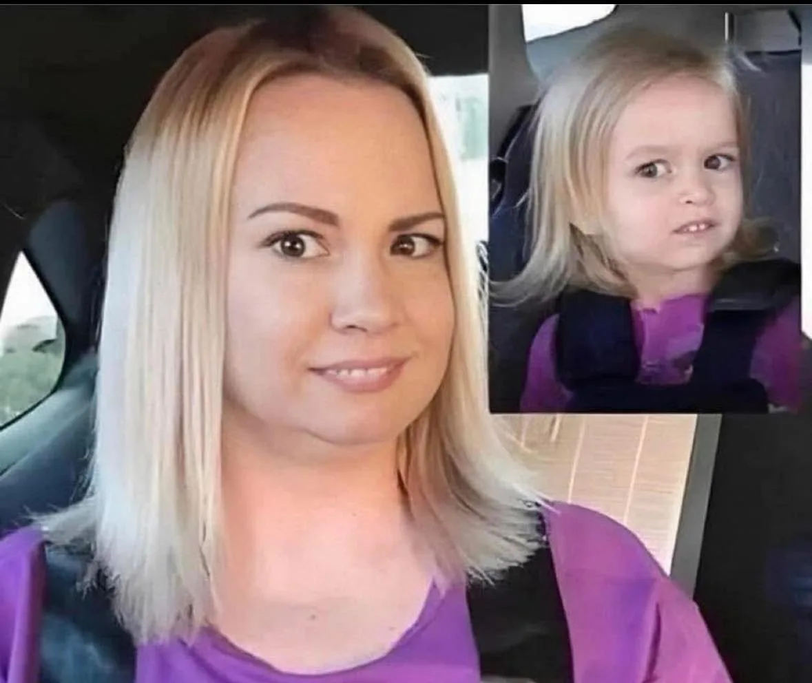 A woman with blonde hair and a purple shirt is in a car, smiling slightly while looking at the camera. In the top right…