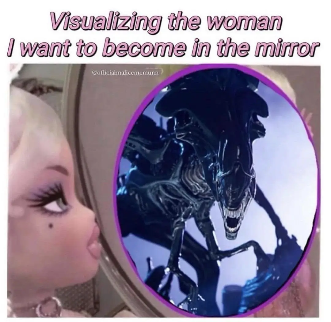 A person with heavy makeup and blonde hair looks into a mirror, which reflects an image of the Xenomorph from the movie…