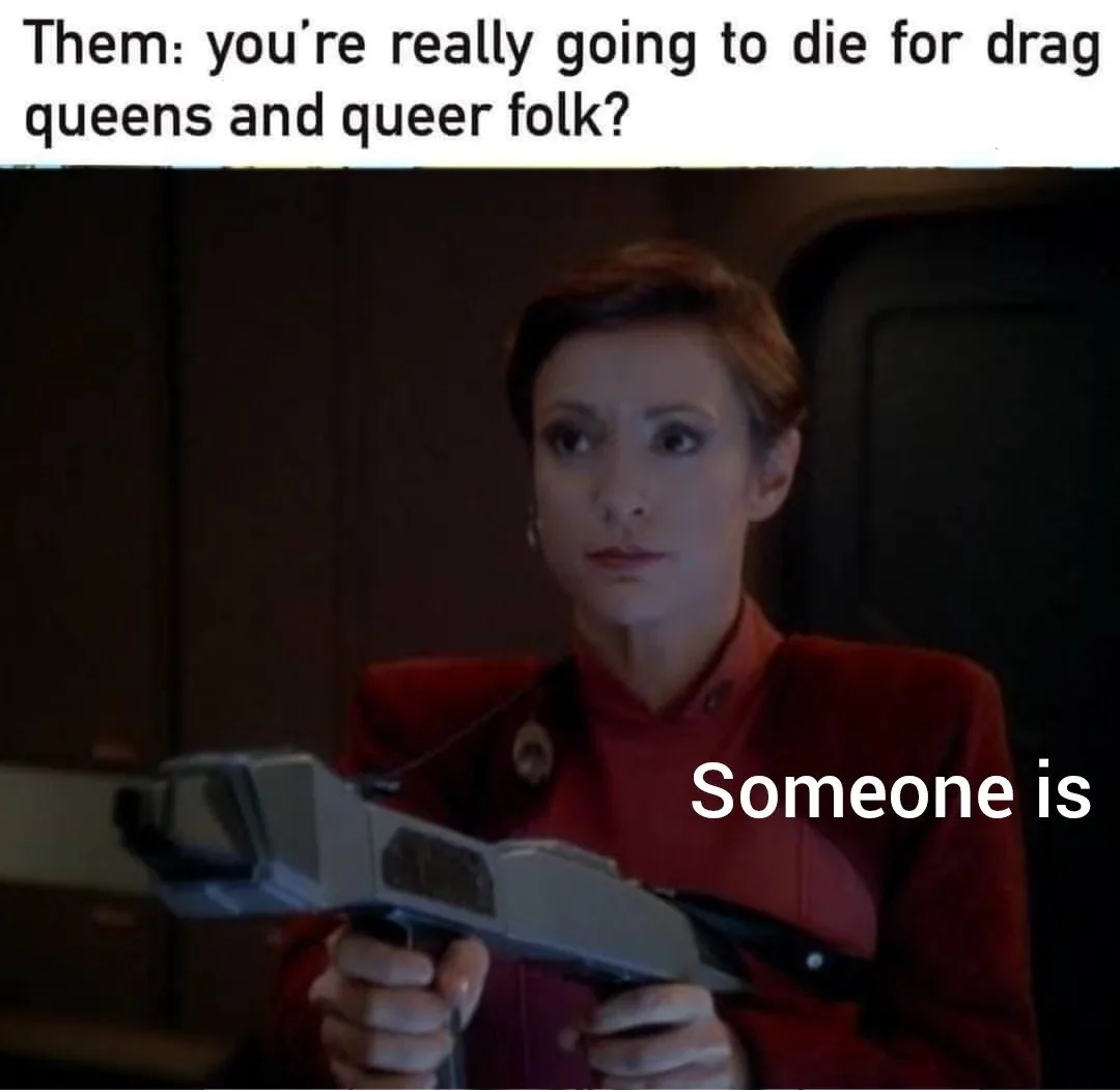 A woman in a red Star Trek uniform holds a phaser with a serious, slightly incredulous expression. The top text asks, 'Them…