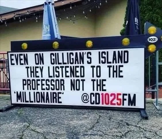 A white marquee sign with black lettering is placed outdoors on cracked pavement, featuring the text 'EVEN ON GILLIGAN'S…