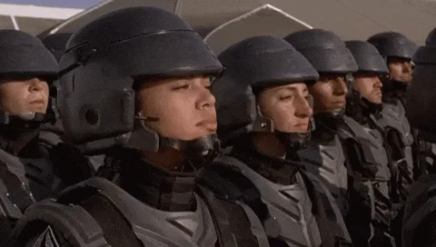 A composite image showing a sequence of frames from a movie where a young soldier in a helmet and uniform repeatedly shouts…