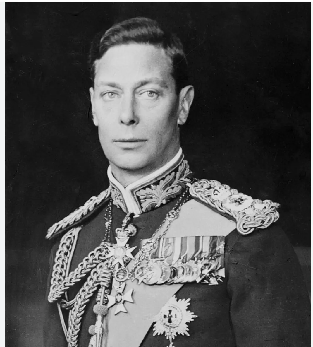 A black-and-white formal portrait of a man in ornate military uniform adorned with numerous medals and decorations. He has a…
